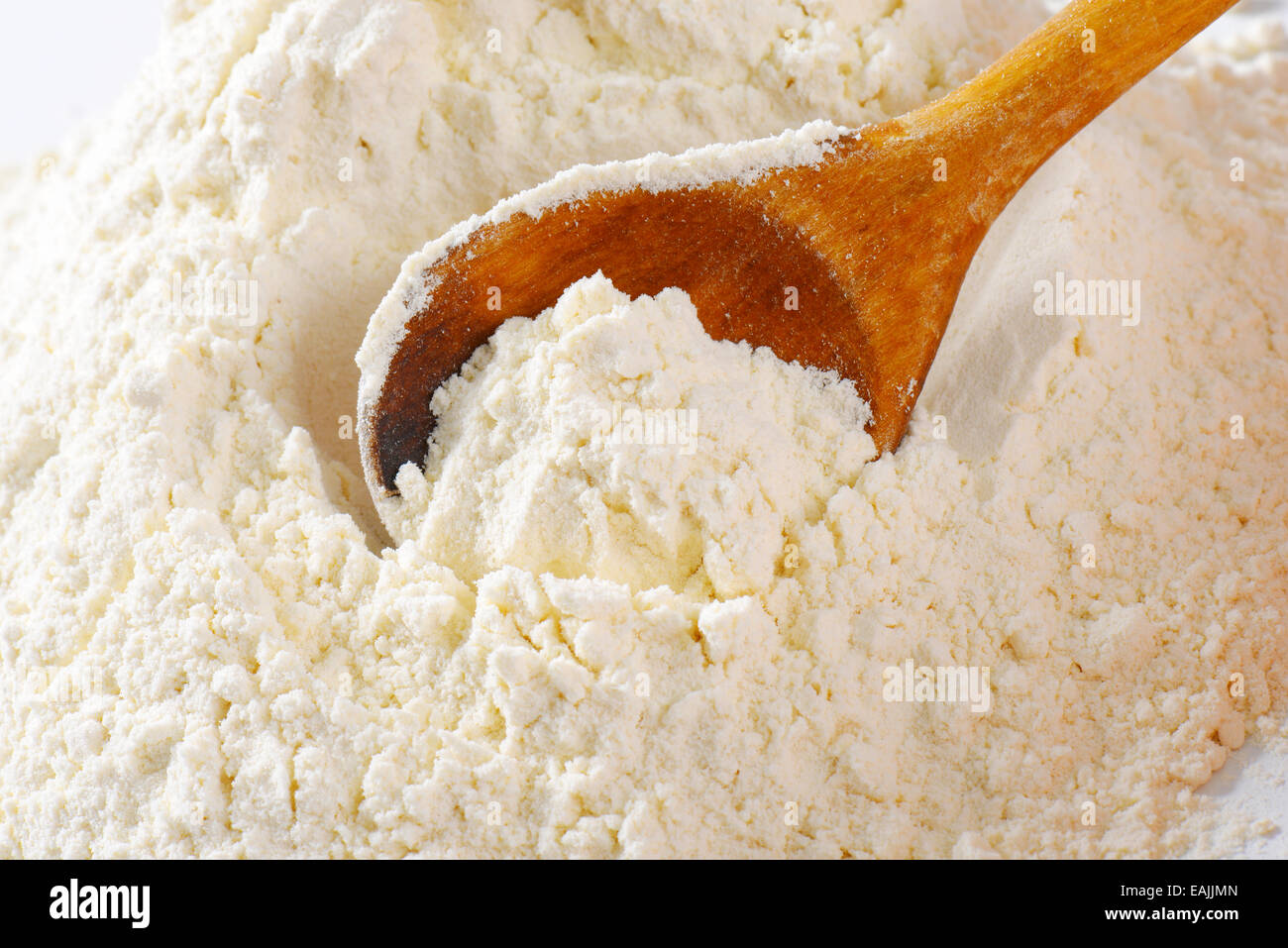 Pile of finely ground flour and wooden spoon Stock Photo