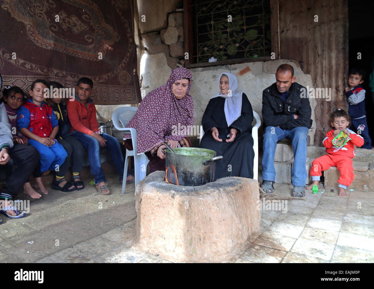 A Palestinian woman sit at her destroyed house, which was destroyed ...