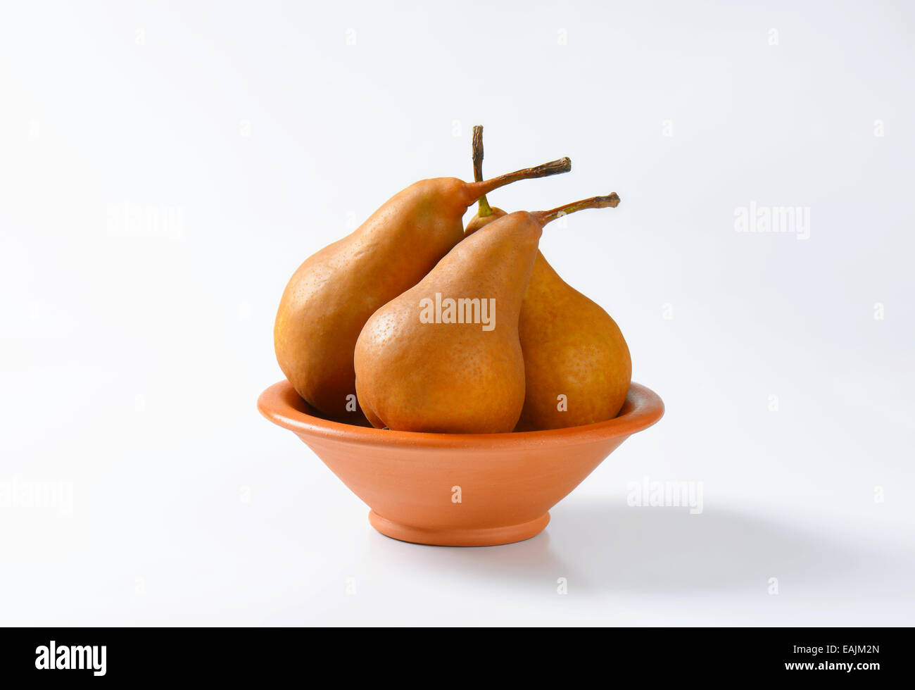 Ripe Bosc pears in a terracotta bowl Stock Photo