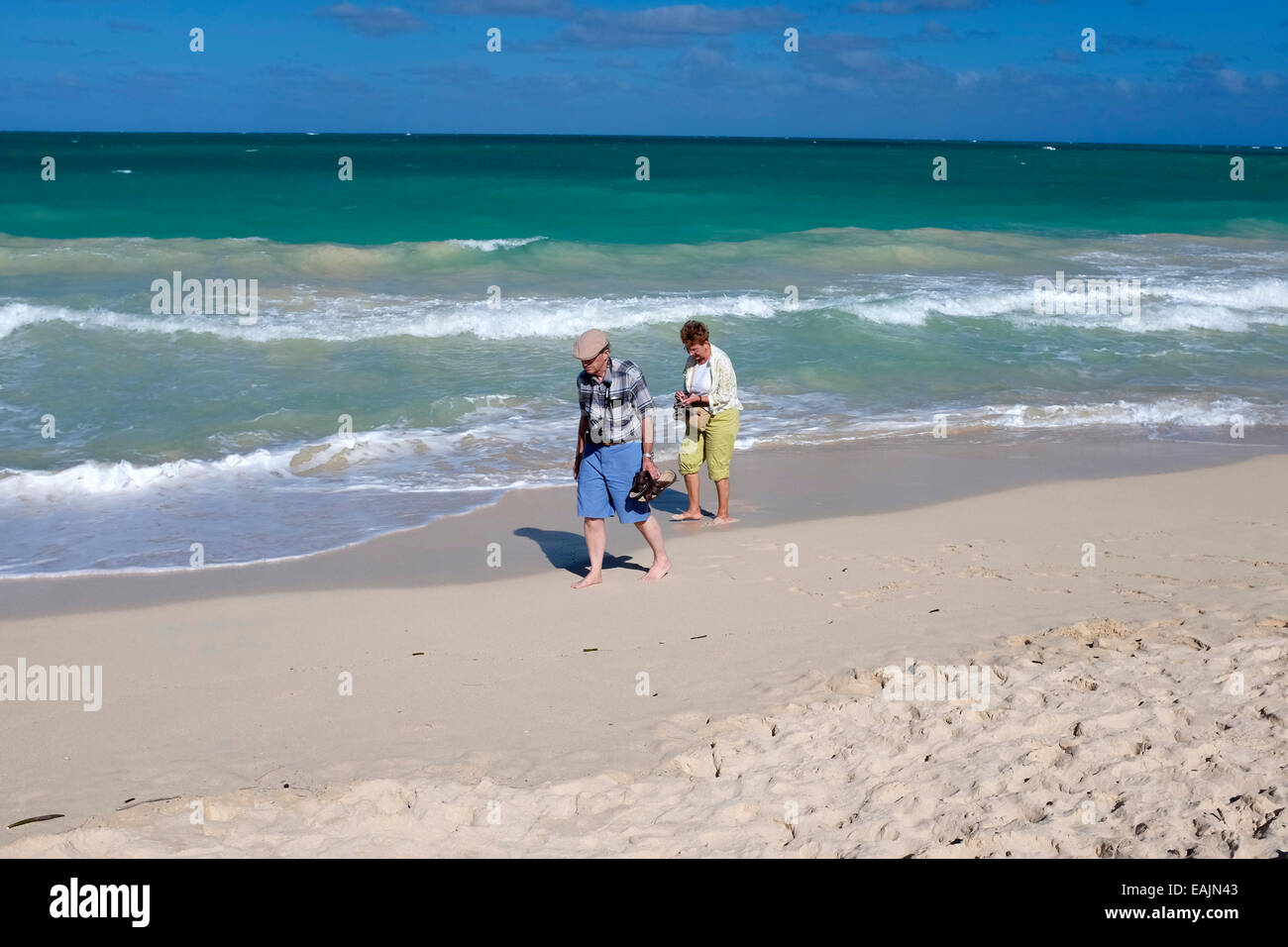 Older couple walking on the beach in Oahu, Hawaii Stock Photo