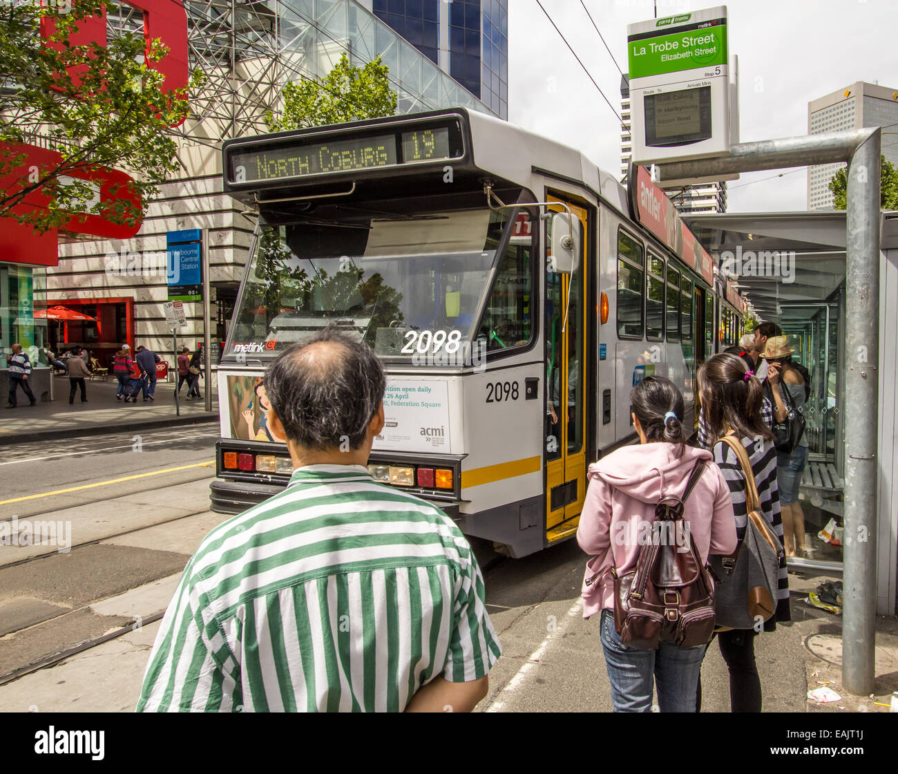 Passengers waiting to board a tram in Melbourne Stock Photo