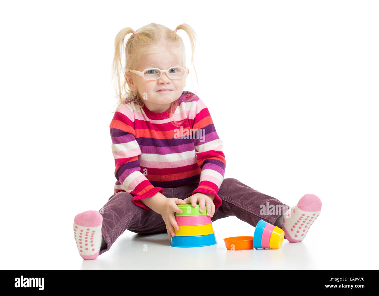 Funny child in eyeglases playing colorful pyramid toy isolated Stock Photo
