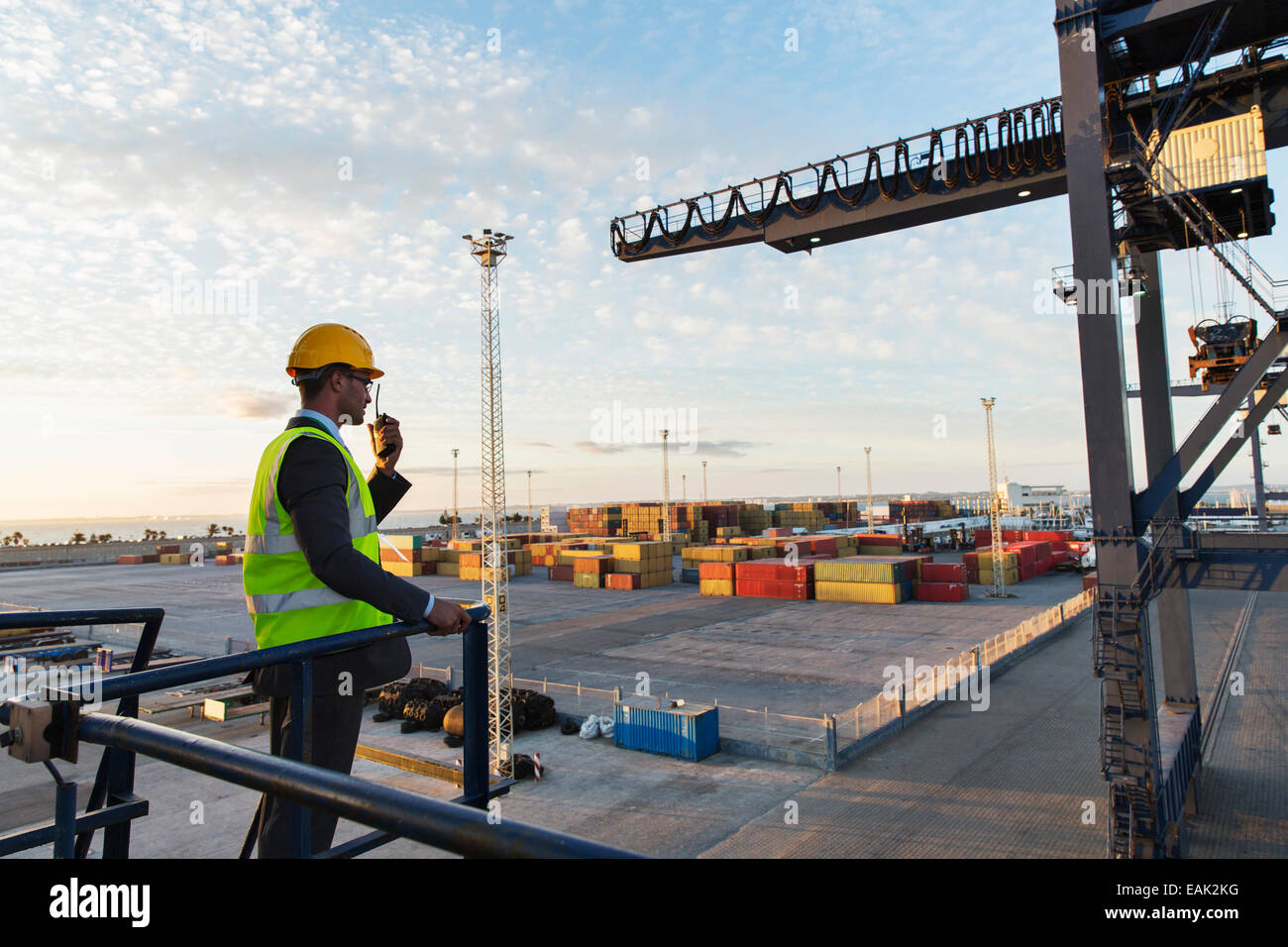Worker using walkie-talkie near crane Stock Photo