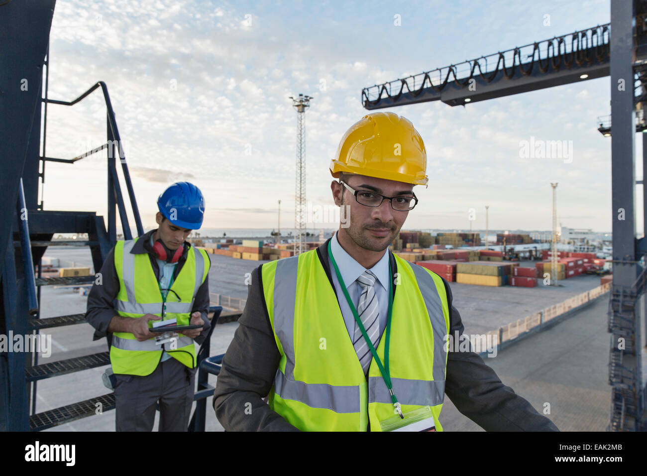 Businessman smiling near cargo crane Stock Photo
