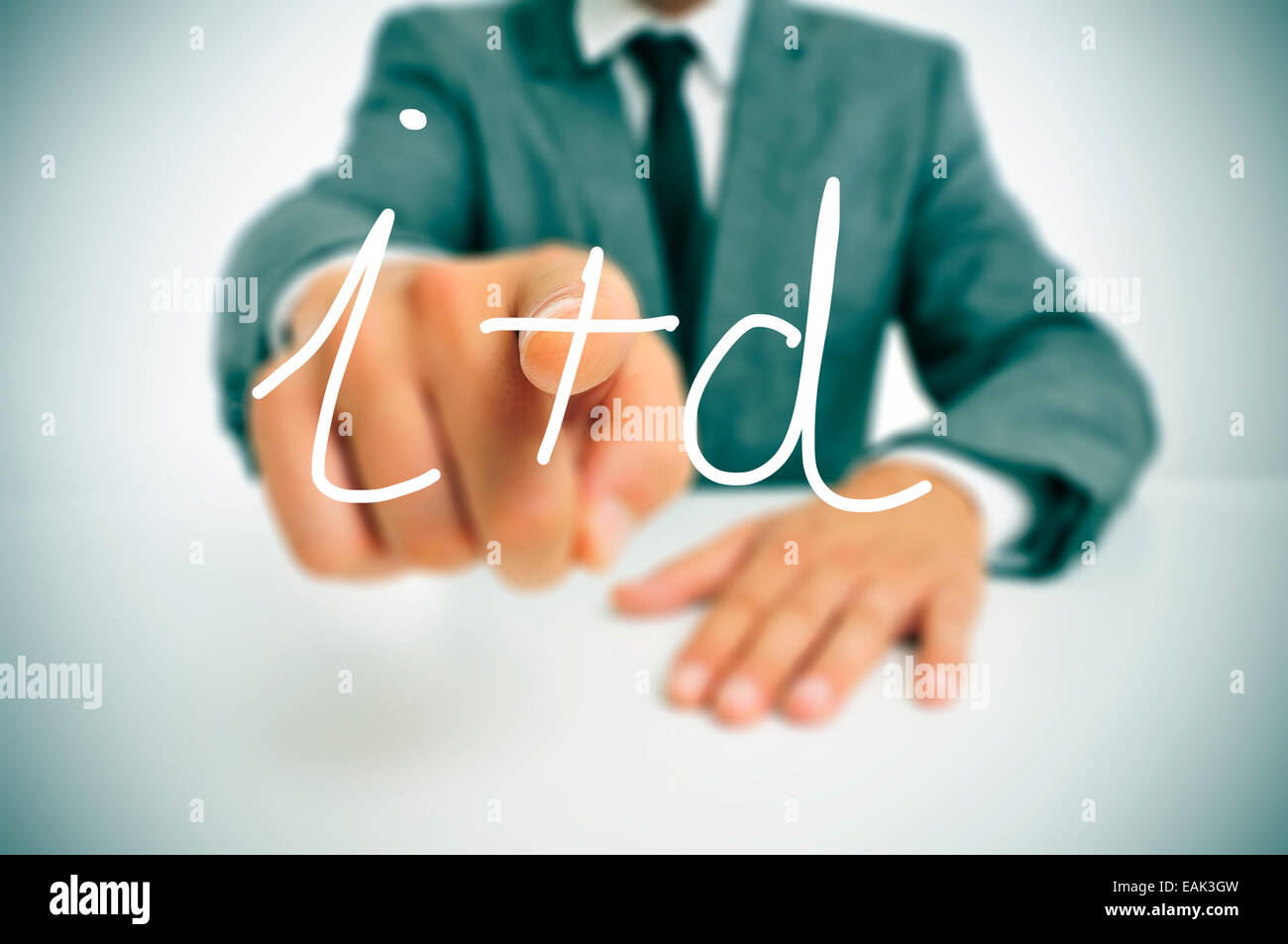 businessman wearing a suit pointing to the term I plus D, investigacion y desarrollo, research and development in spanish, writt Stock Photo
