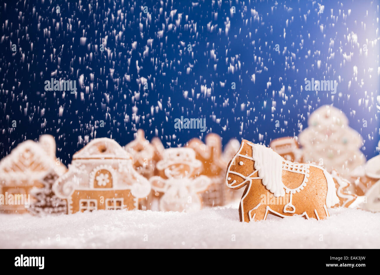 Macro photo of gingerbread village with falling snow Stock Photo