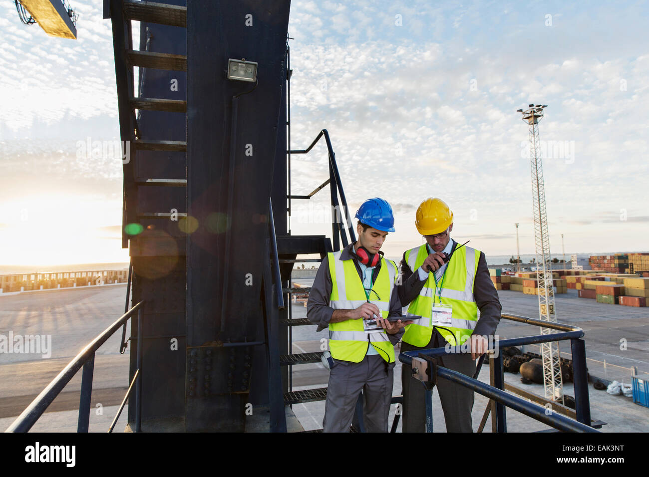 Workers using walkie-talkie on cargo crane Stock Photo