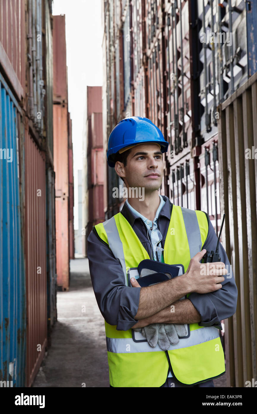 Worker standing between cargo containers Stock Photo