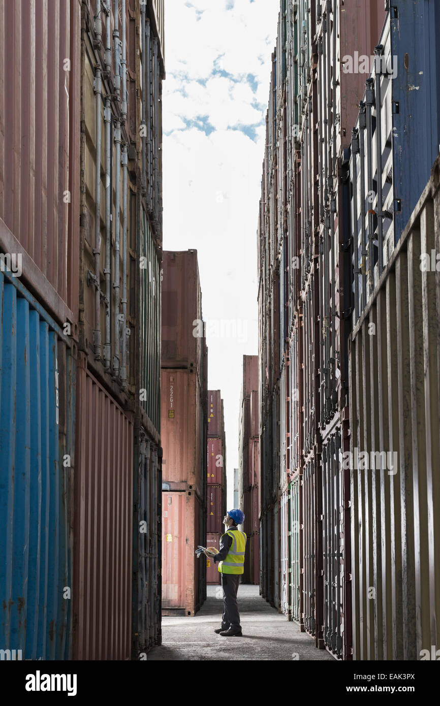 Worker standing between cargo containers Stock Photo