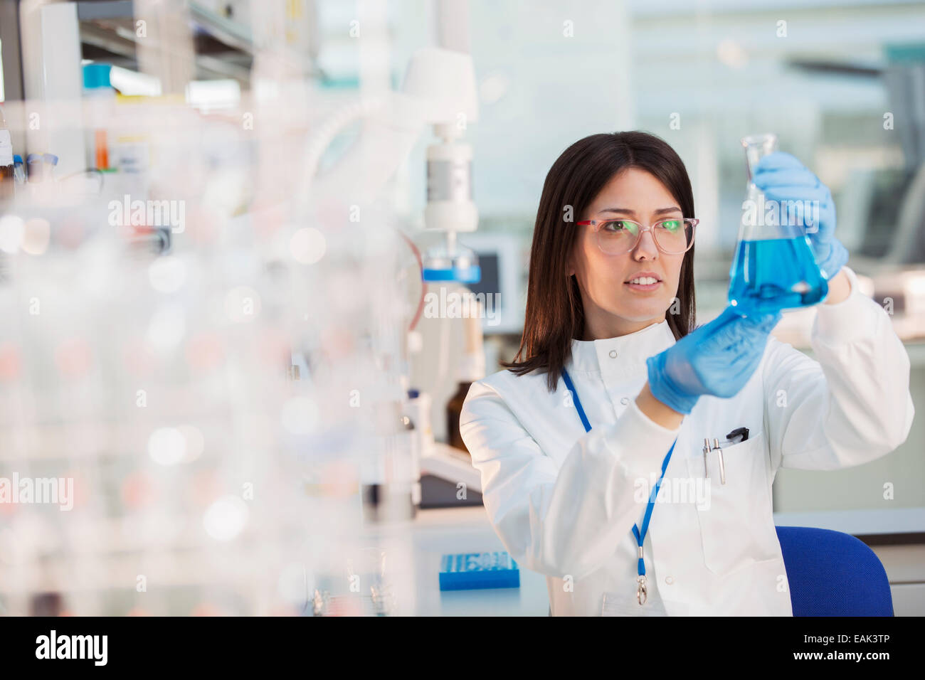 Scientist examining sample in beaker in laboratory Stock Photo