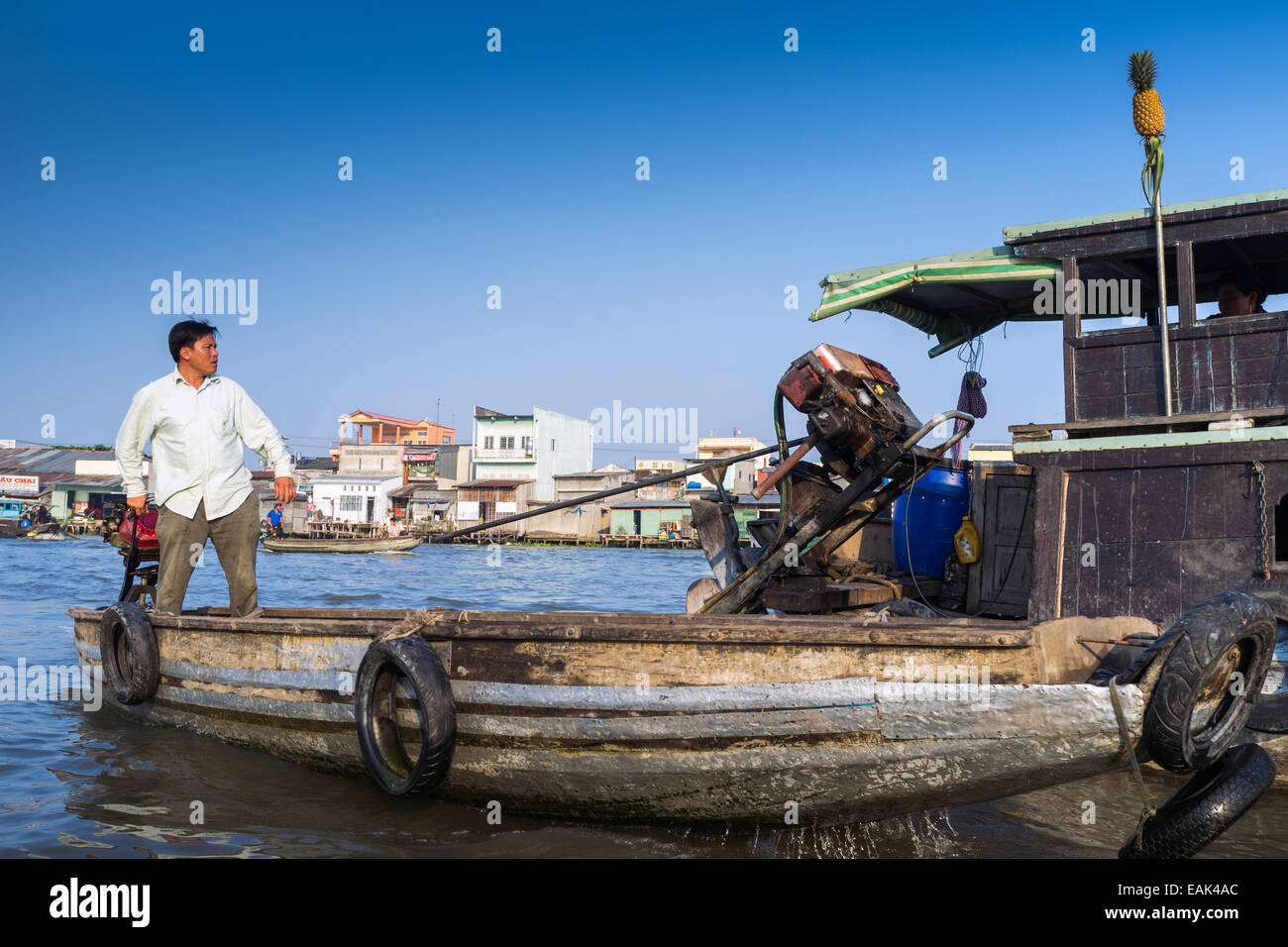 A man rowing her boat through the floating markets in the Mekong Delta ...