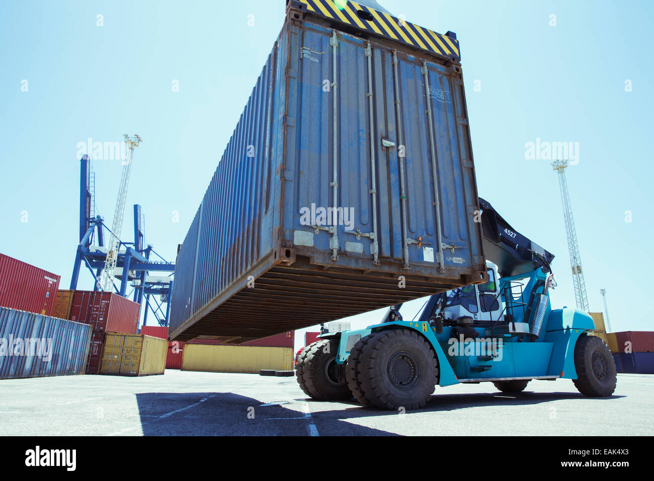 Low angle view of crane lifting cargo container Stock Photo