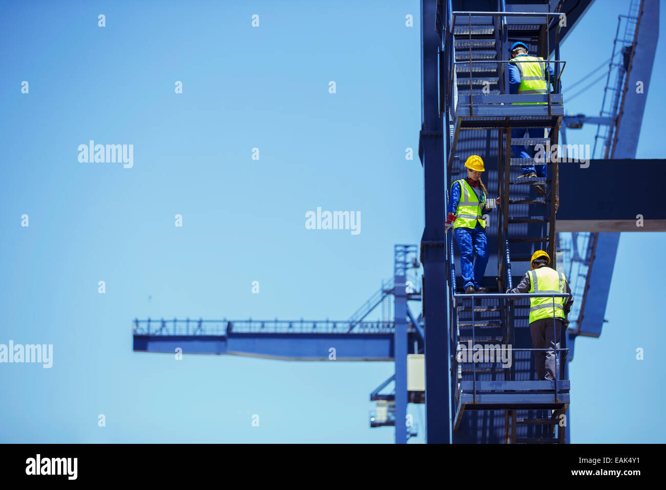 Workers climbing cargo crane Stock Photo