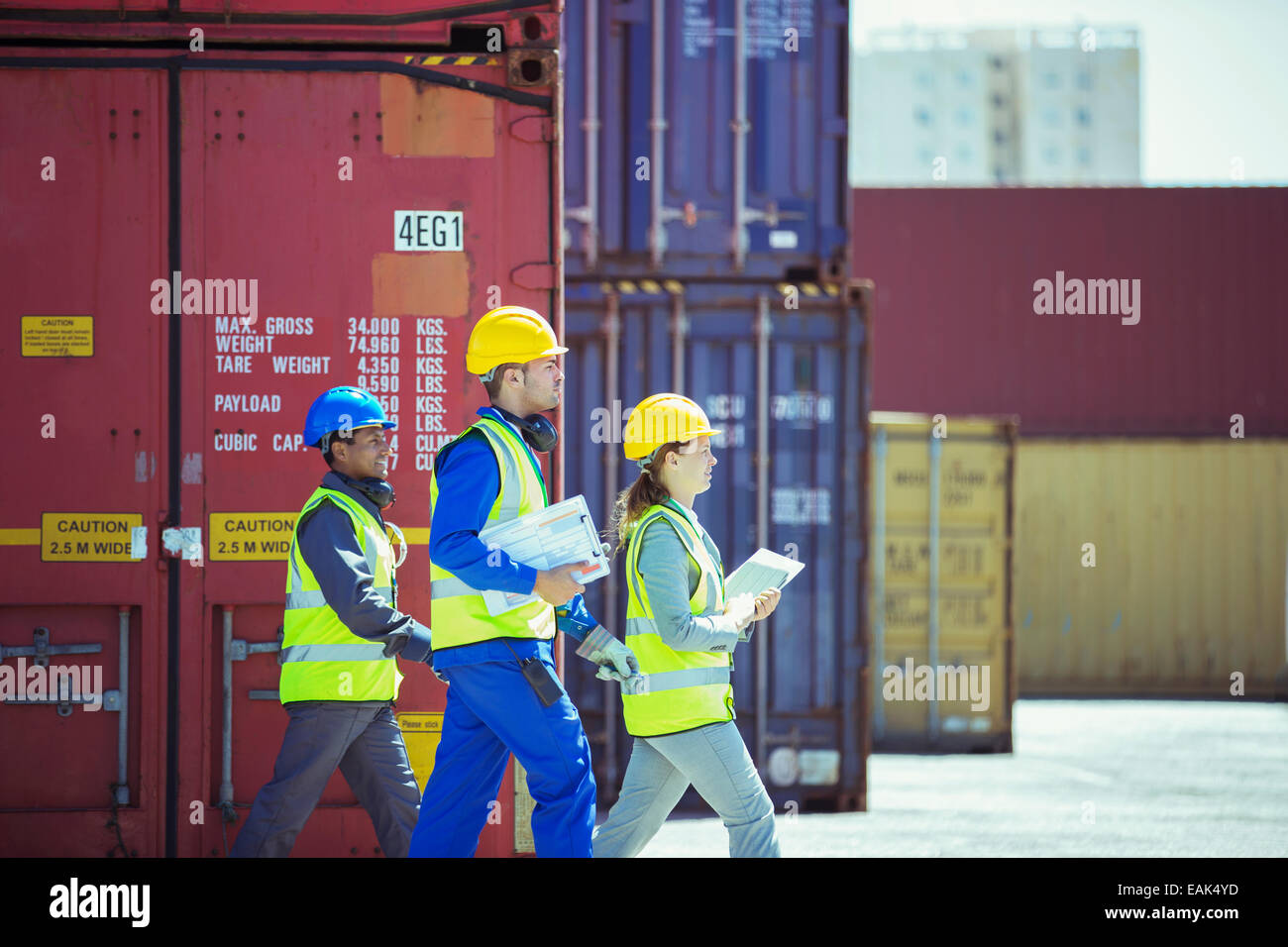 Business people and worker walking near cargo containers Stock Photo