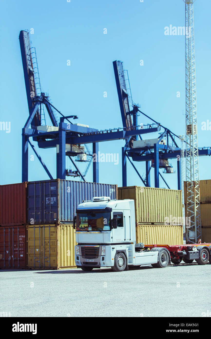 Cranes over cargo containers and truck Stock Photo