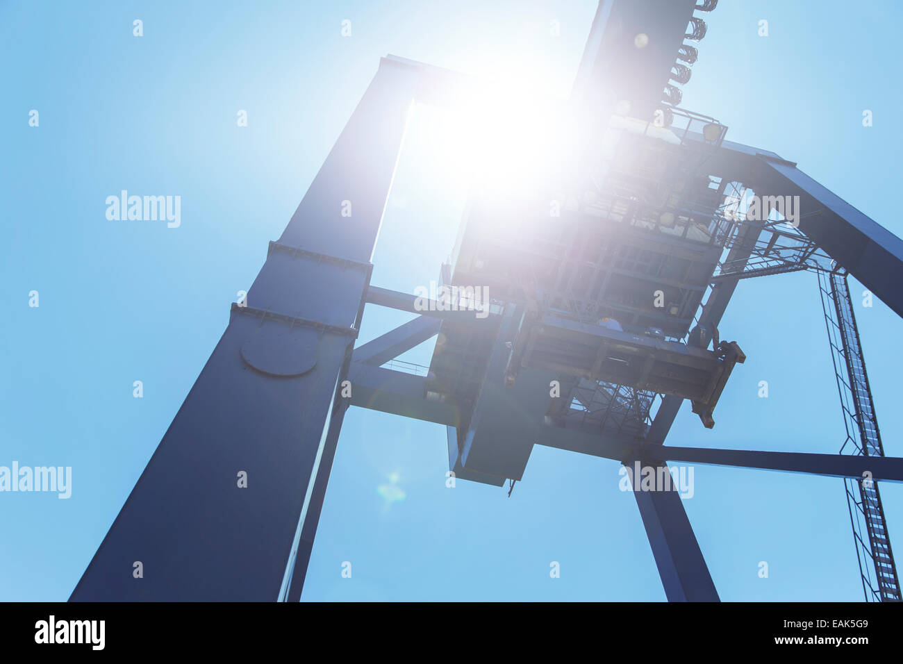 Low angle view of cargo crane against blue sky Stock Photo