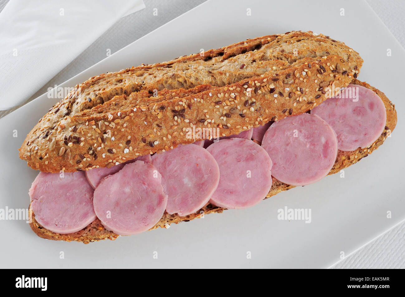 a whole wheat bread submarine sandwich with turkey ham on a set table