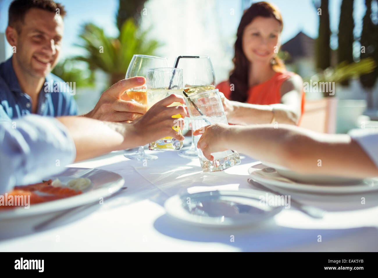 Friends raising toast at table outdoors Stock Photo