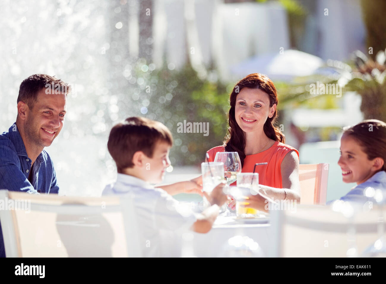 Family with two children raising toast at table outdoors Stock Photo