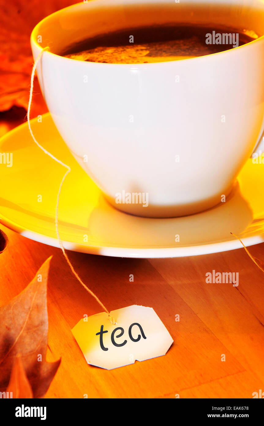 closeup of a cup with a tea bag being steeped, on a wooden table Stock Photo