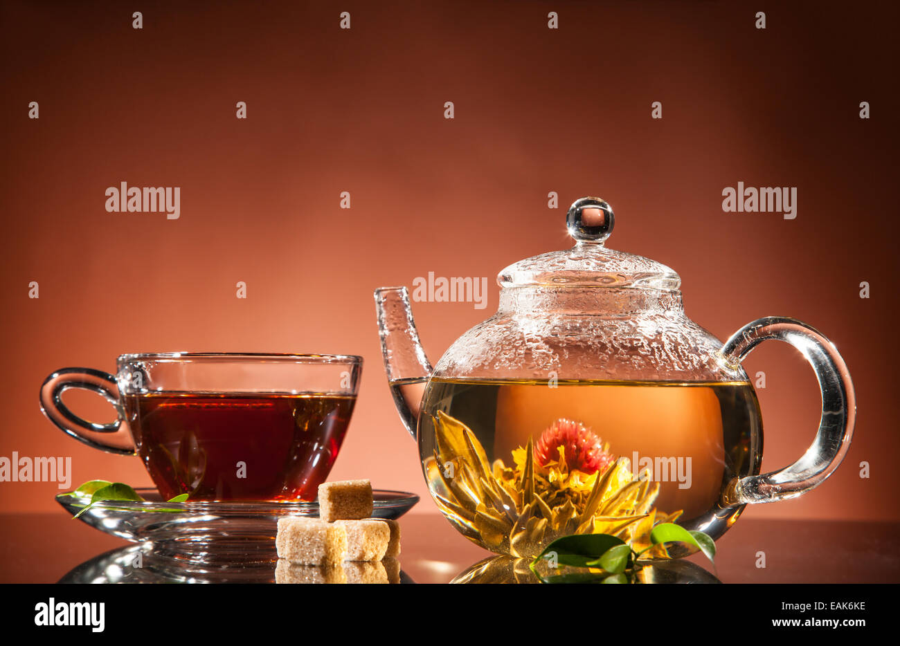 Teapot and cup with blooming tea on glass Stock Photo Alamy