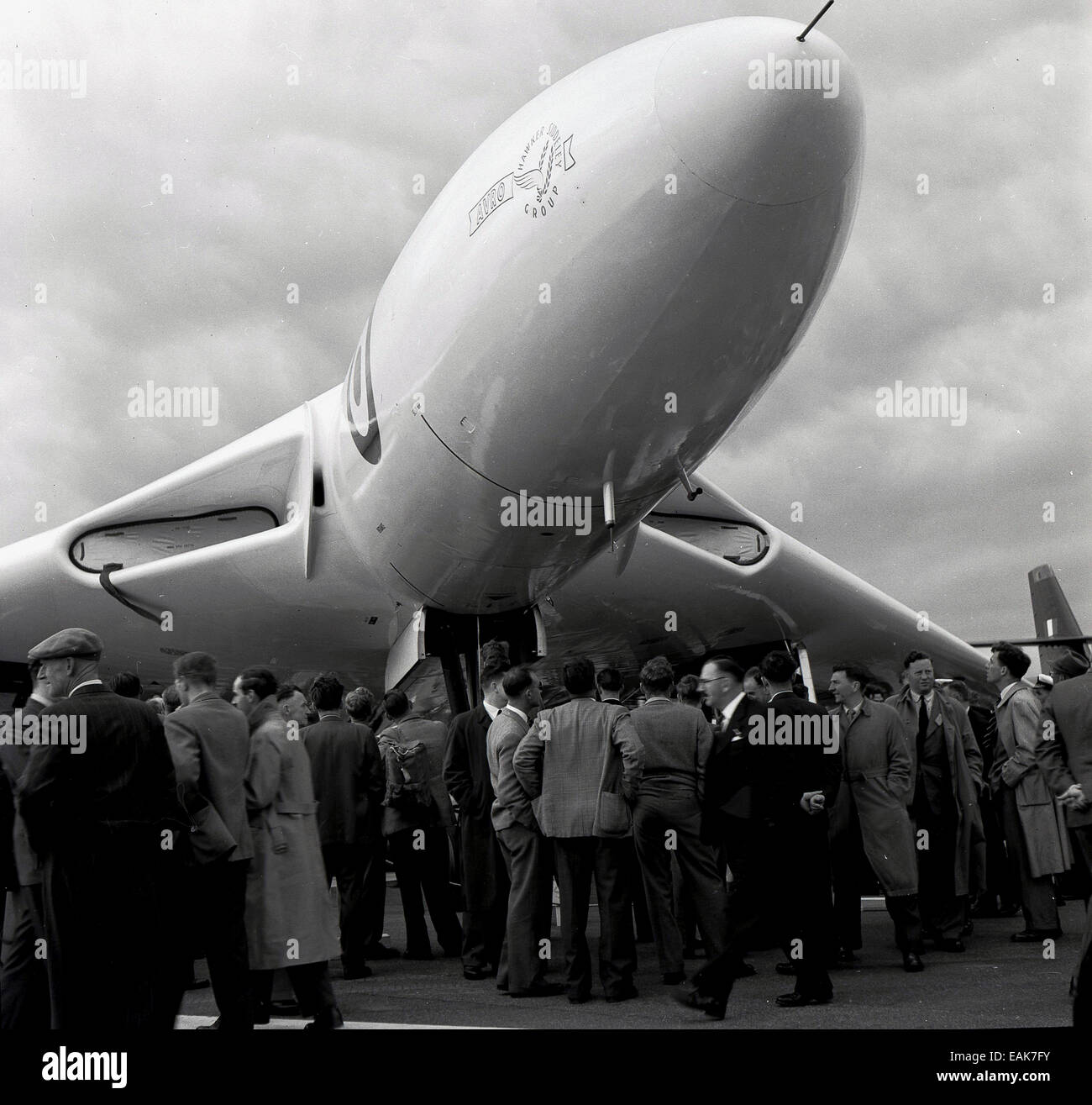 1950s, historical, members of the press congregate outside underneath the cockpit of the new fighter jet-powered delta wing strategic bomber, The Avro Vulcan B.2, at its press launch, England, UK. Stock Photo