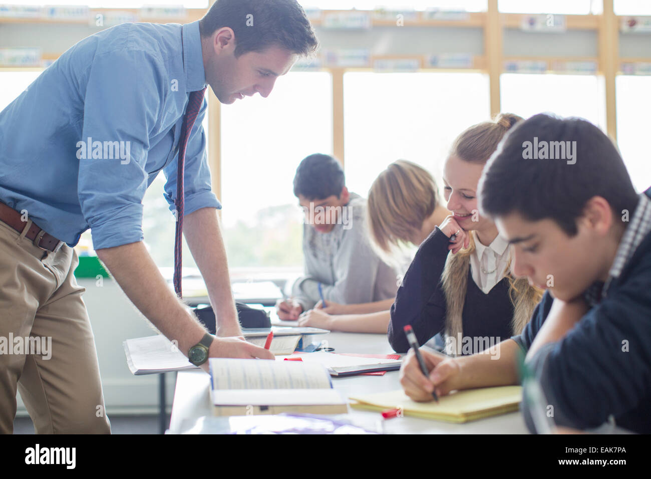 Teacher helping his students in classroom Stock Photo