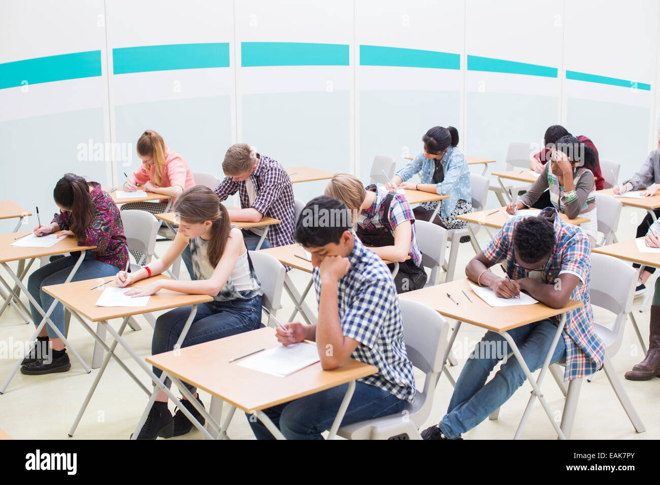 Students writing their GCSE examination in classroom Stock Photo