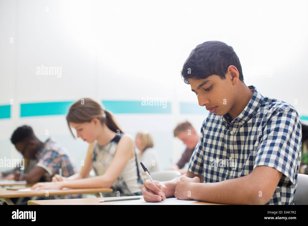 Students writing their GCSE examination in classroom Stock Photo