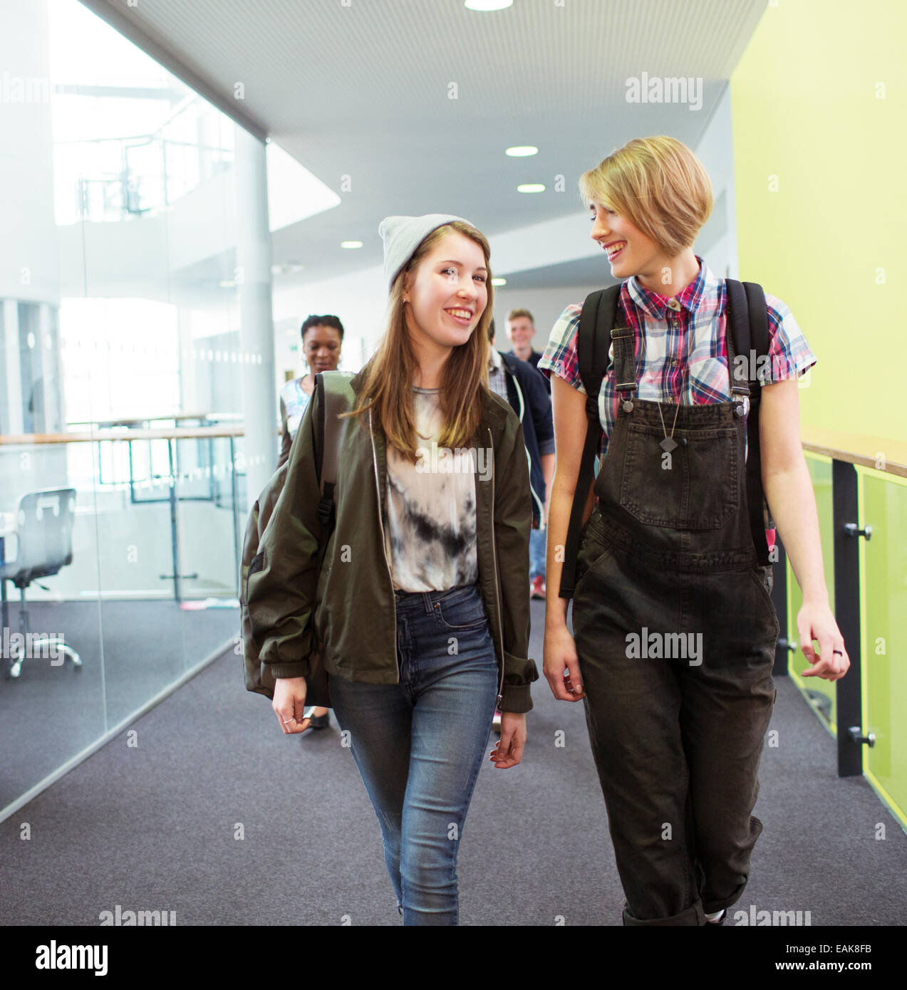 Group of cheerful students walking in corridor Stock Photo