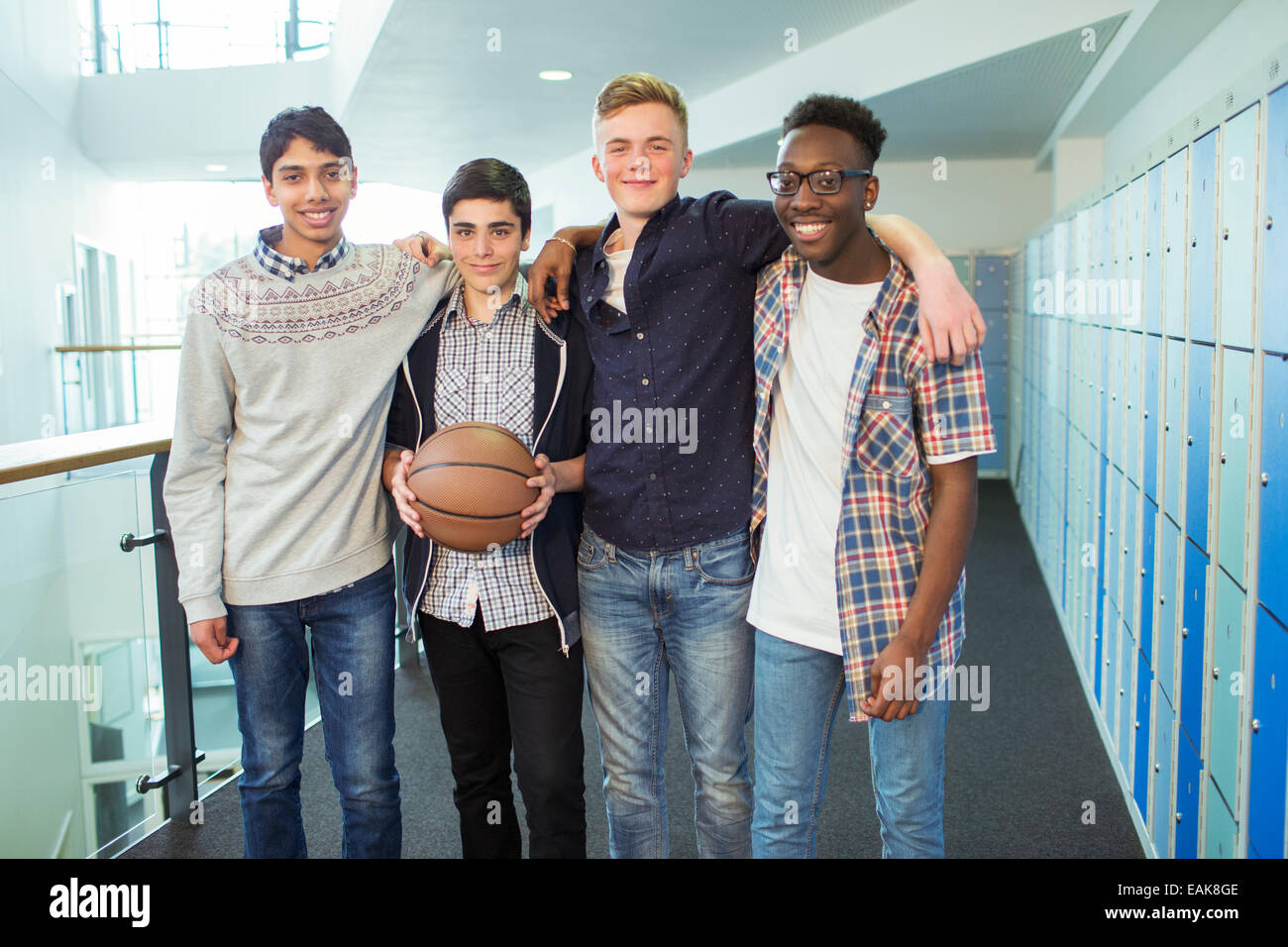 Group portrait of male students holding basketball in school corridor Stock Photo