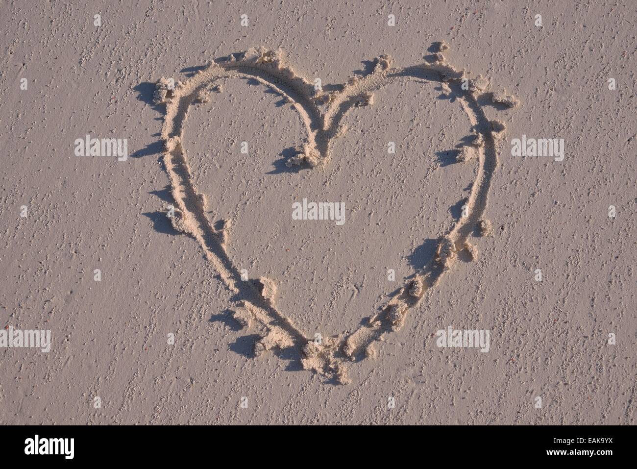 Heart drawn in the sand Stock Photo