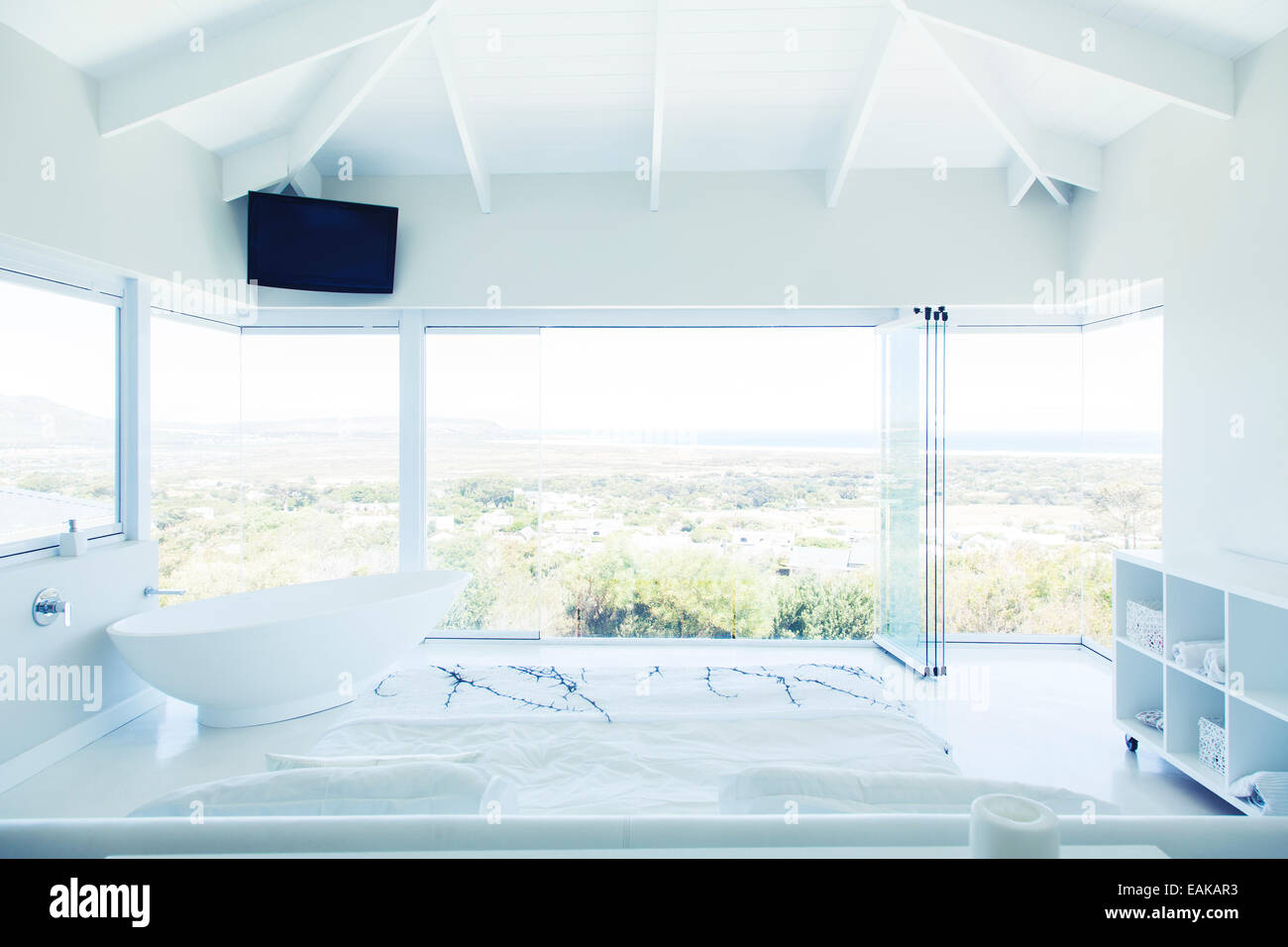 Modern white bedroom interior with double bed and bathtub Stock Photo ...