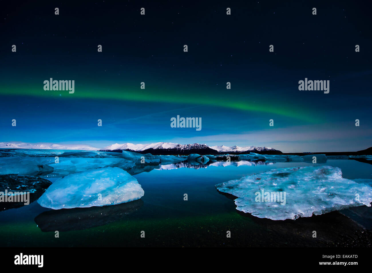 Chunks of ice in the water at the blue hour with polar lights, Jökulsárlón lake, Vik, Iceland Stock Photo