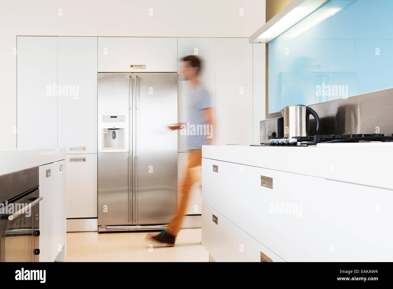 Man walking towards refrigerator in his modern kitchen Stock Photo