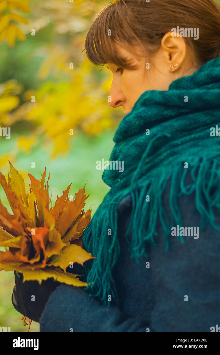 girl in autumn park with a bouquet of fallen maple leaves Stock Photo ...