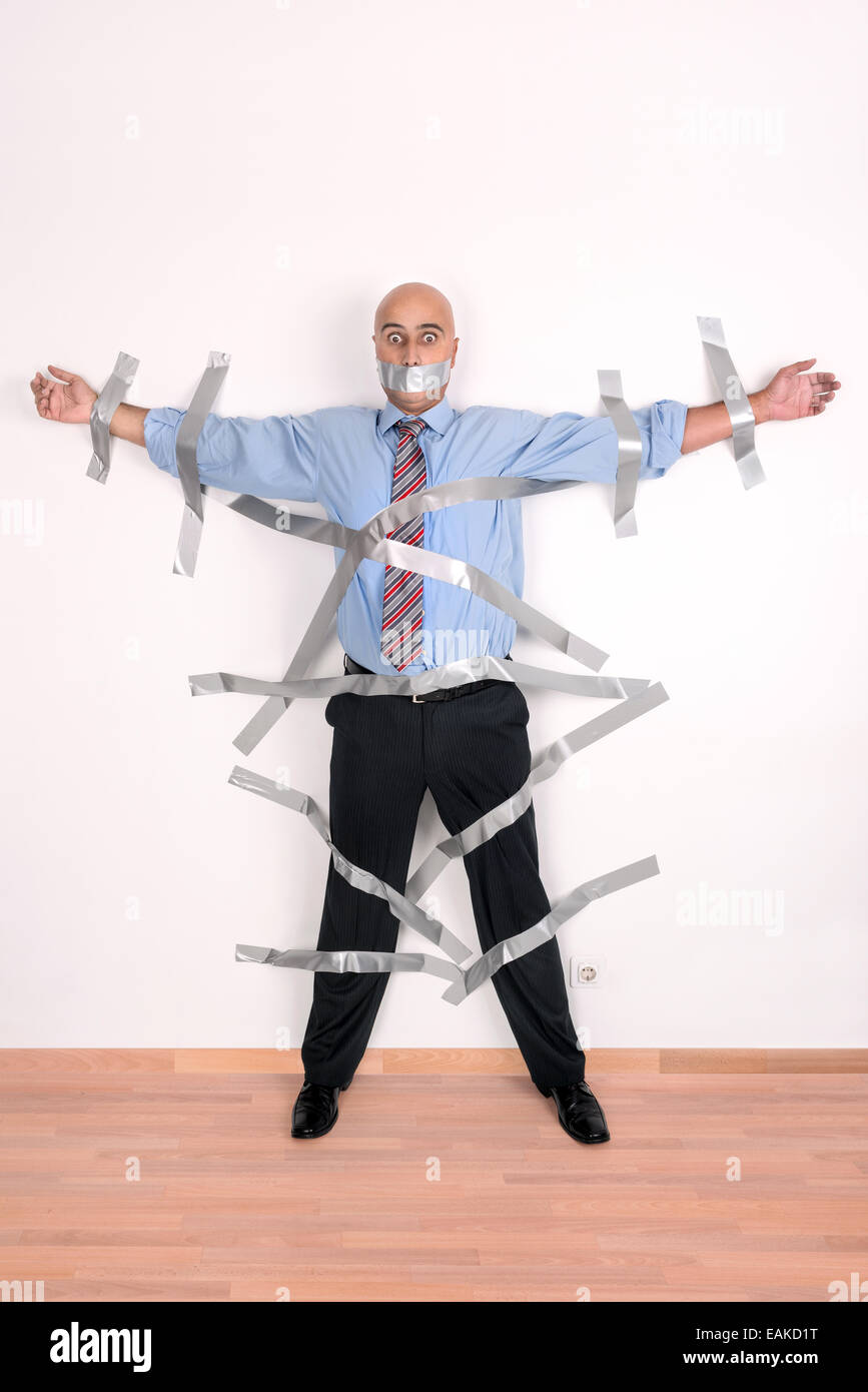 Businessman glued to the wall with duct tape Stock Photo