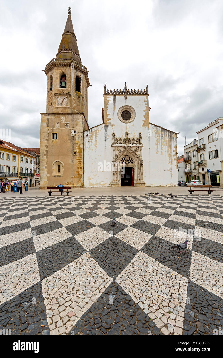 Church and bell tower of Sao Joao Baptista with a geometric paving pattern on the marketplace of Tomar, Tomar Stock Photo