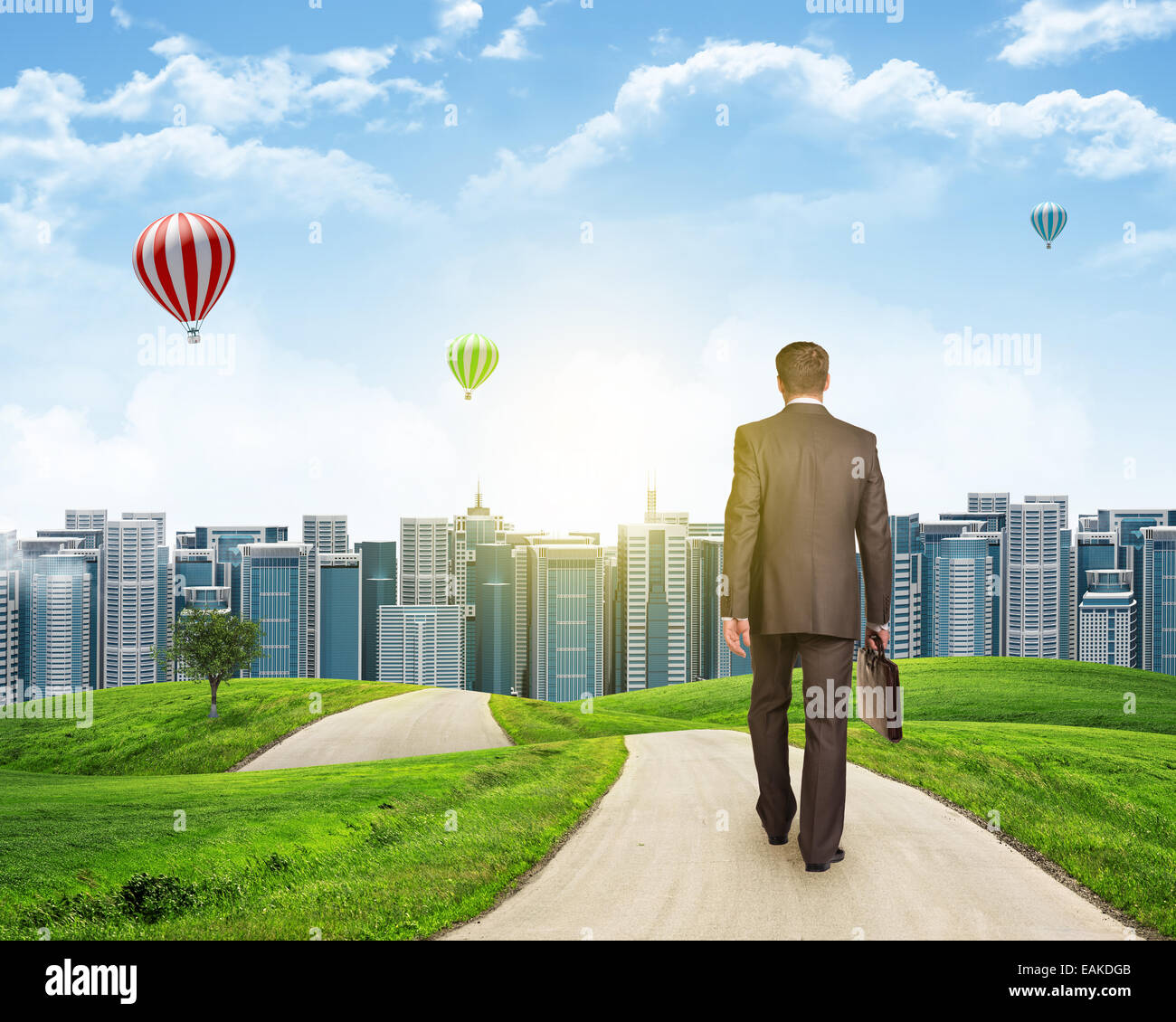 Businessman walks on road. Rear view. City skyline, grass field and sky