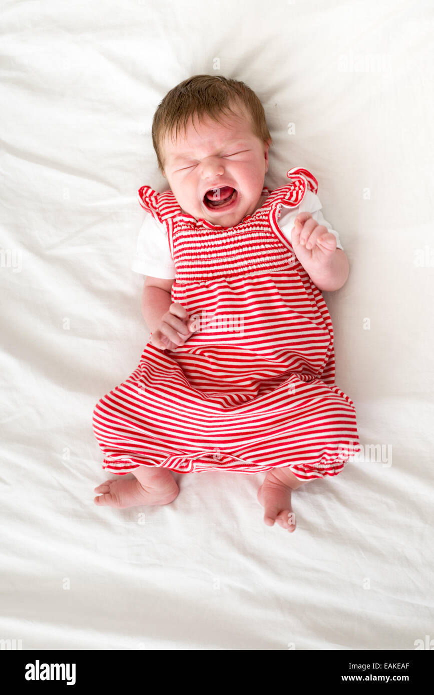 Four day old newborn baby girl crying loudly Stock Photo