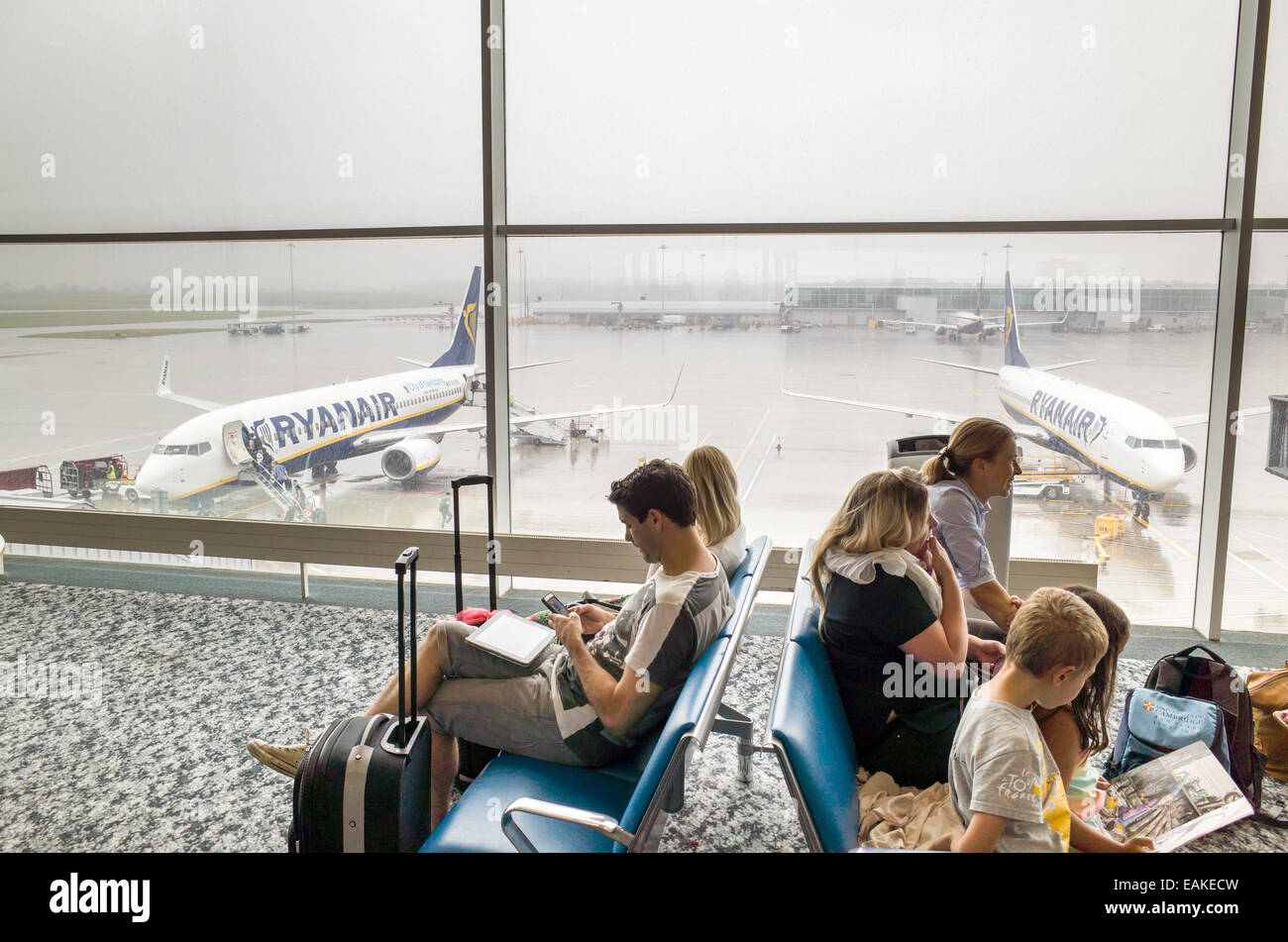 Passengers waiting to board Ryanair plane at Stansted Airport departure gate, England, UK Stock Photo