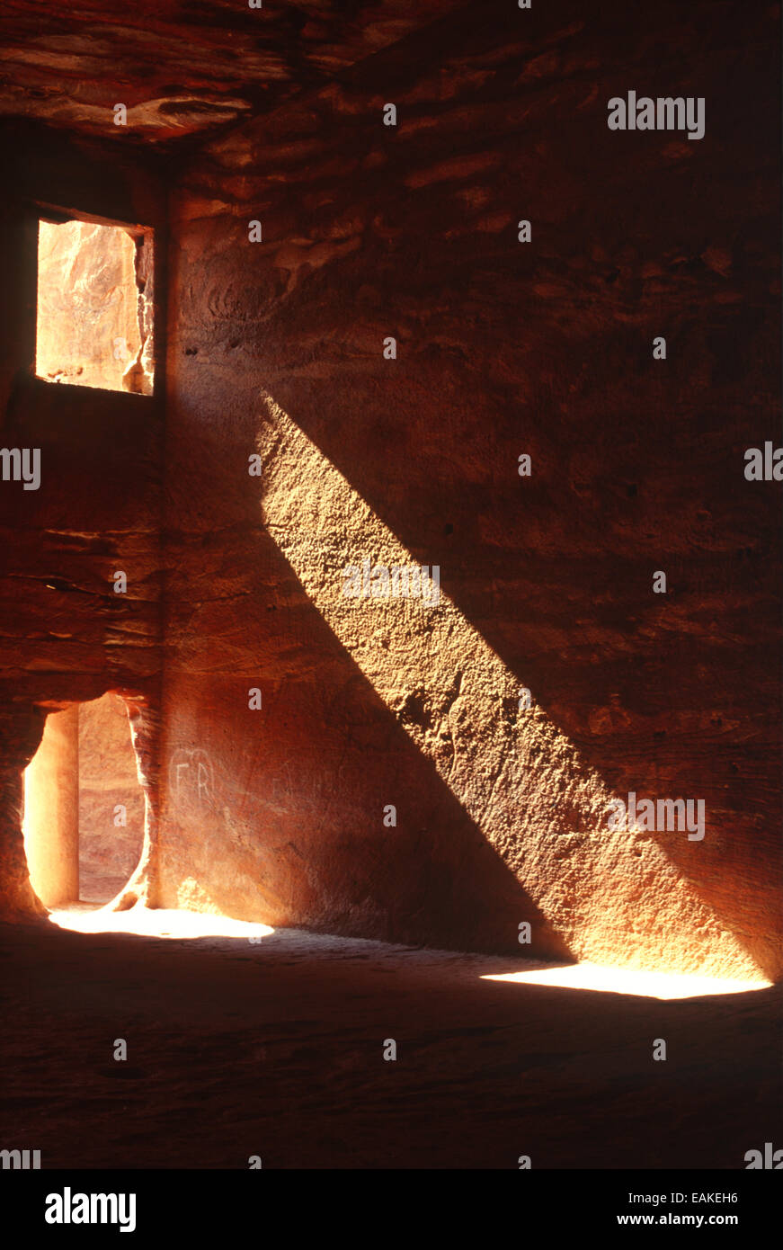 A shaft of light shines through an opening of the Urn Tomb in Petra, Jordan Stock Photo