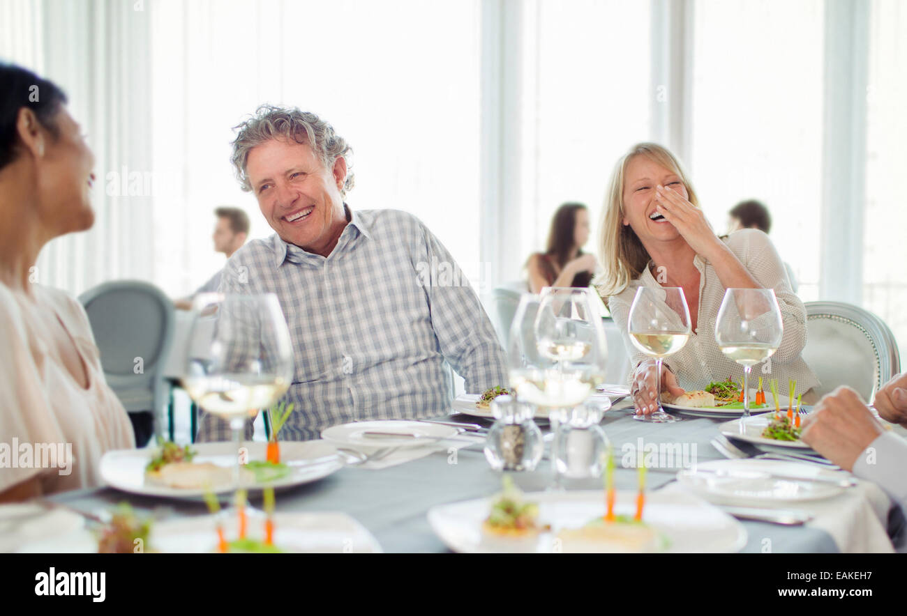 Cheerful people laughing at restaurant table Stock Photo