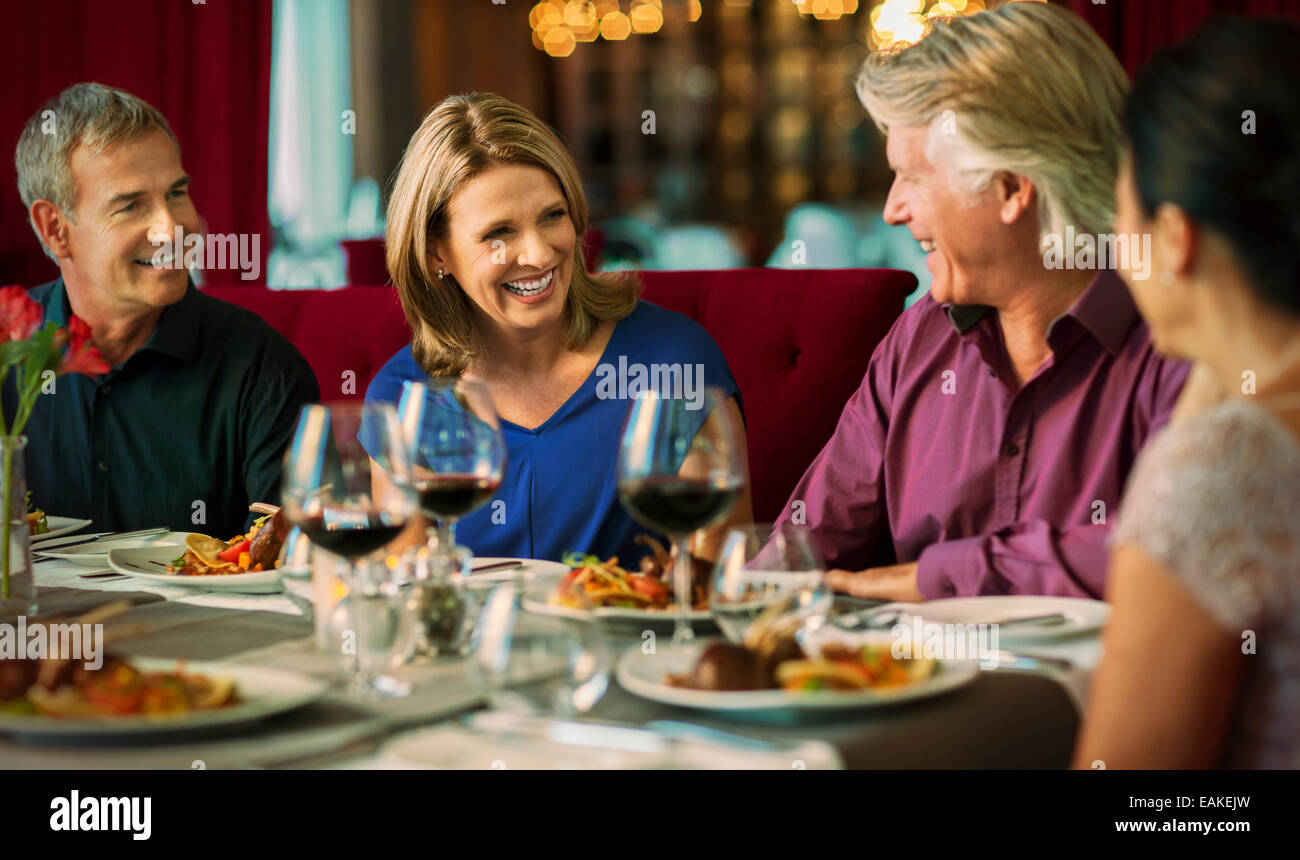 Smiling people enjoying their meal in restaurant Stock Photo