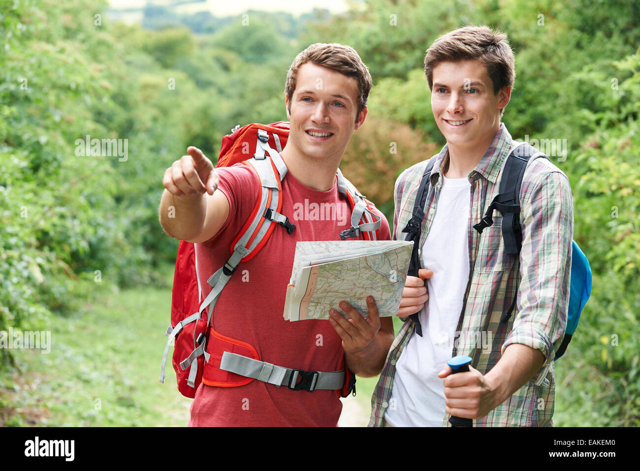 Two Young Men Hiking In Countryside Together Stock Photo