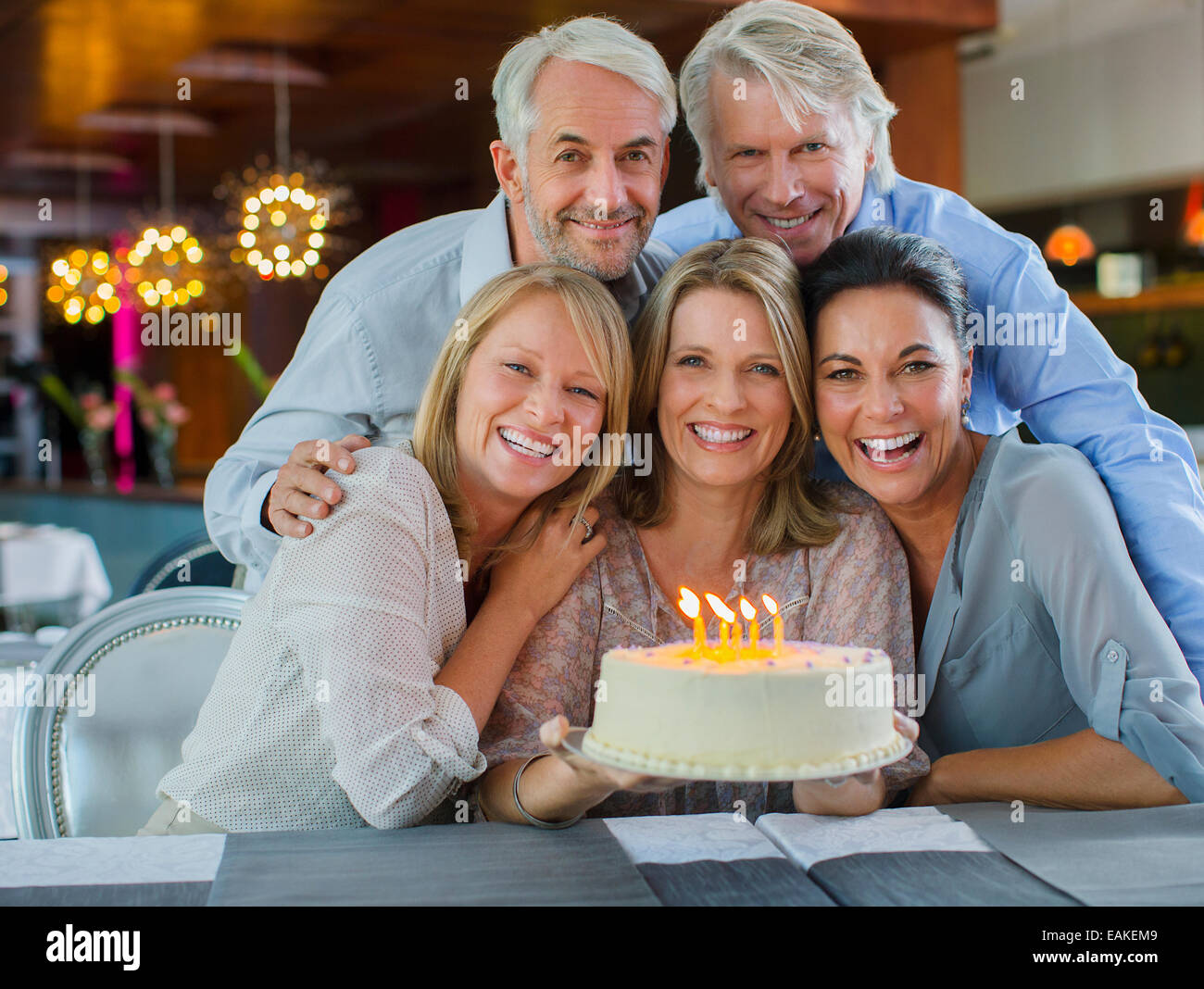Portrait of smiling mature men and women with birthday cake Stock Photo