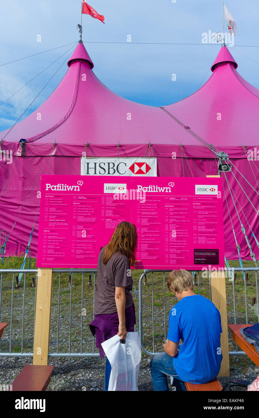 A woman looking at the timetable of events outside the iconic pink pavilion at the National Eisteddfod of Wales, Llanelli, Augus Stock Photo
