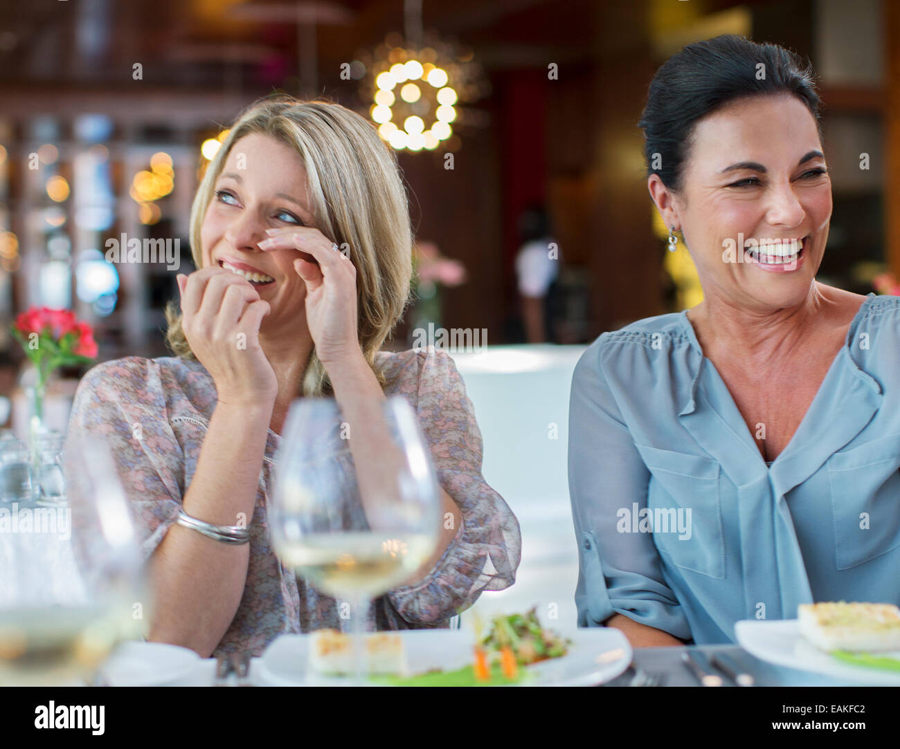 Women laughing at table in restaurant Stock Photo