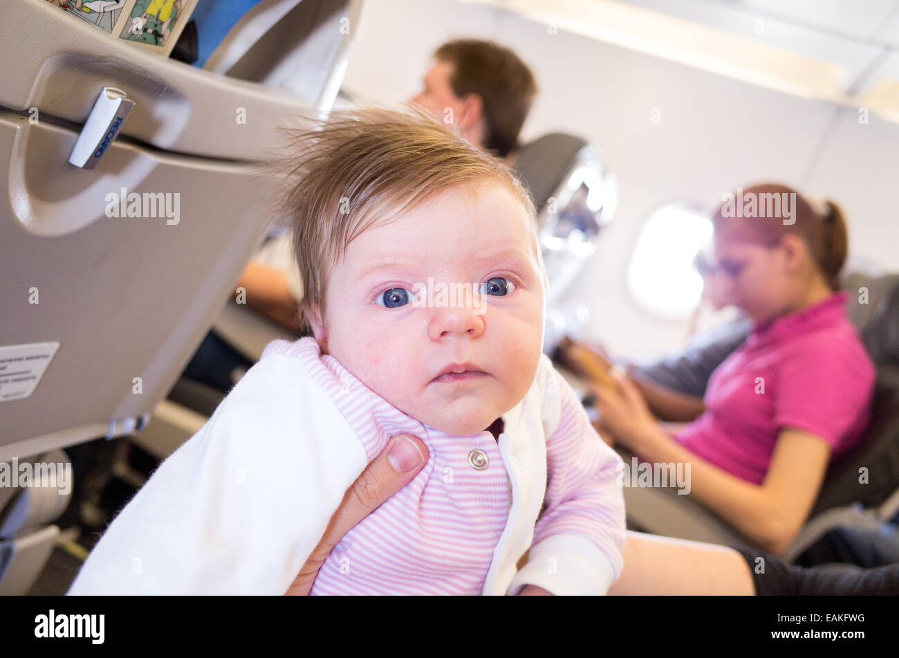 Travelling on an aeroplane with a one month old baby girl Stock Photo