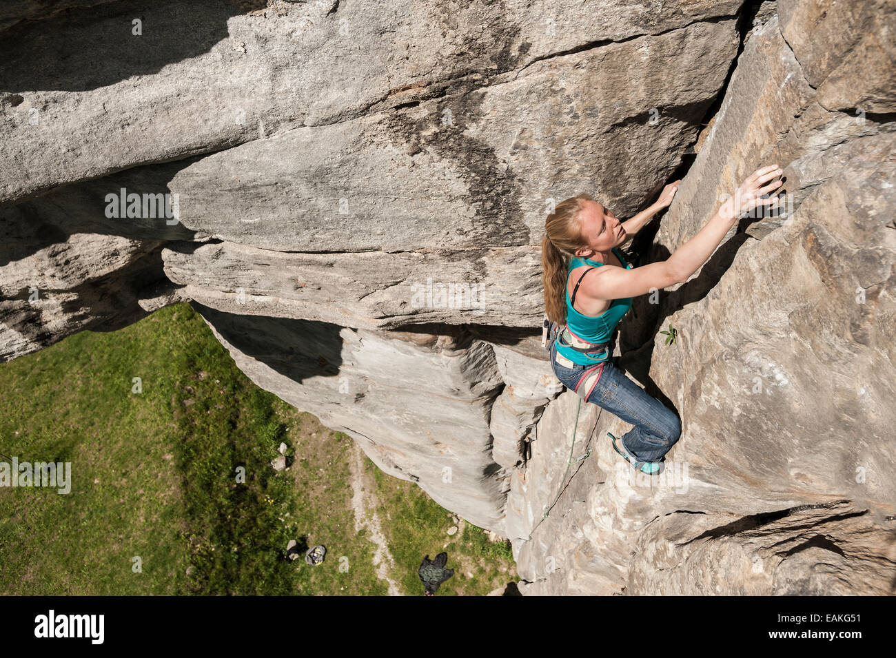 Italian girl climbs a 6b crack route in Balmanolesca, the most historical granite crag in Ossola. Varzo, Italy. Stock Photo